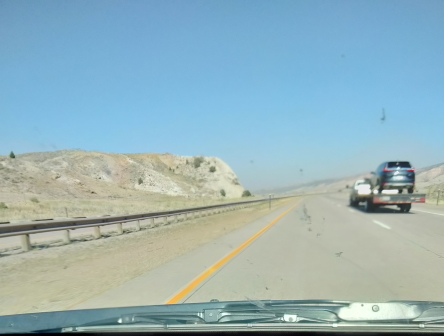 road with light red hills at side