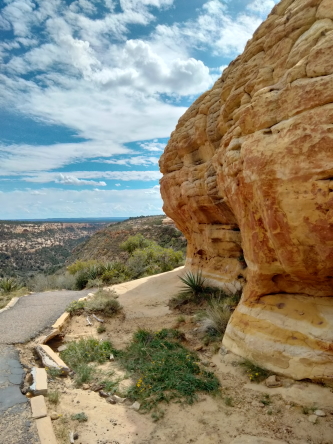 a huge red rock at right of a walking path