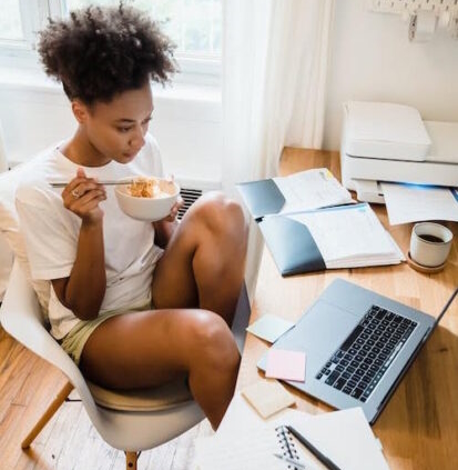 Woman eating breakfast at her desk